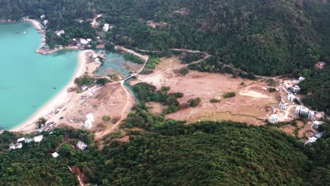 Aerial-truck-left-of-turquoise-water-at-Pui-O-beach-bay-surrounded-by-rainforest-hills-at-daytime-in-Lantau-Island,-Hong-Kong,-China