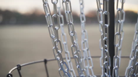 Close-up-of-Disc-Golf-Basket-Chains-while-a-Disc-Golf-Disc-Goes-in