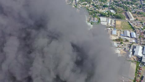 drone flying through big column of rising smoke of building fire