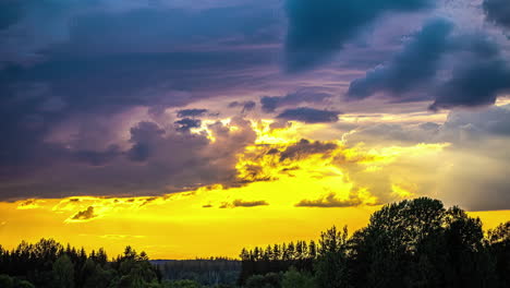 time-lapse de nubes de lluvia oscura sobre un bosque de coníferas sereno con cielo amarillo después de la puesta de sol en el fondo durante la noche