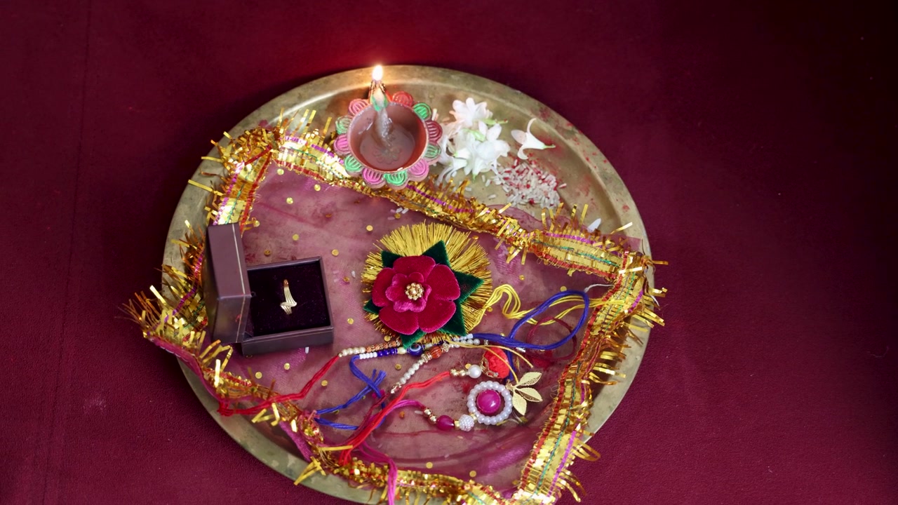 Thali Puja indiano del Raksha Bandhan con Rakhi sacro e accessori festivi e anelli d'oro