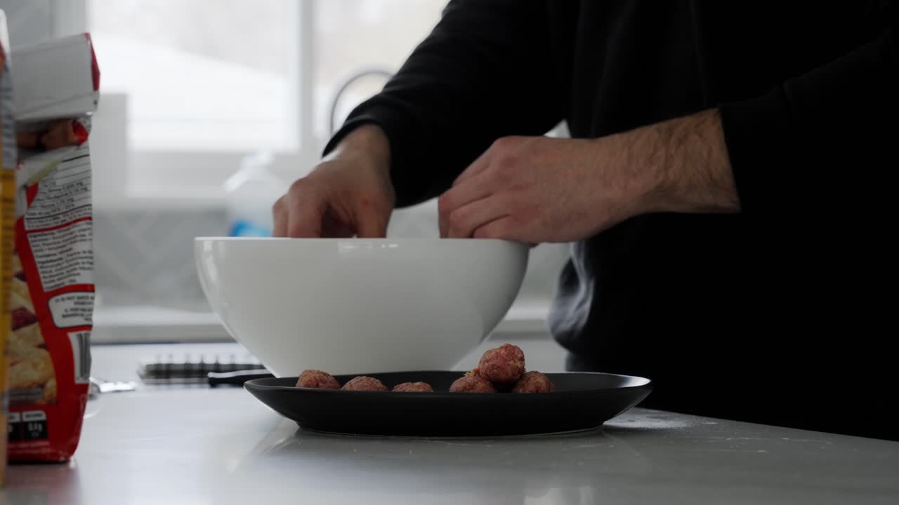 Hand placing seasoned Beef Qebapa mixture into bowl after shaping step. Traditional Albanian Dish