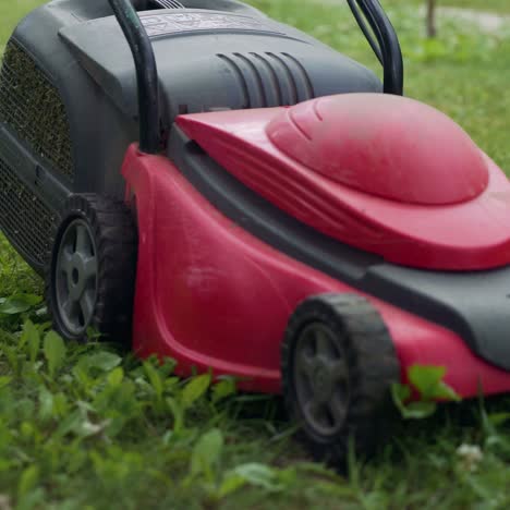 boy running with a lawn mower in the garden. mowing grass in the garden. close-up
