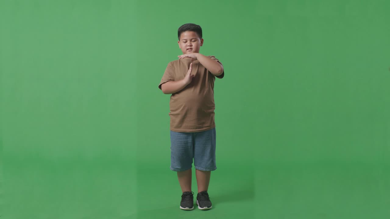 cuerpo lleno de hombre asiático haciendo un gesto de tiempo con las manos mientras está de pie en el fondo de la pantalla verde