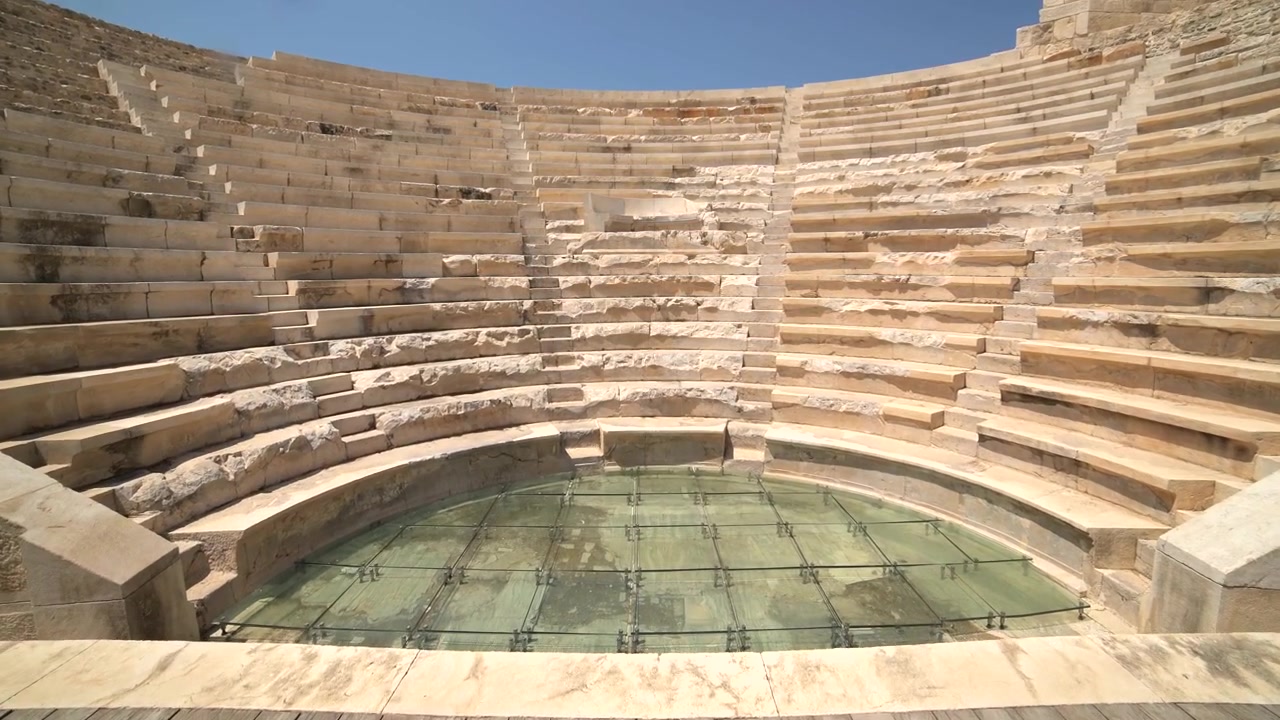 Ruinas de un antiguo teatro romano con asientos de piedra y escenario de cristal