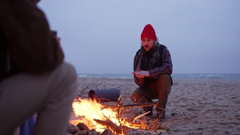 friends by the campfire on the beach at night