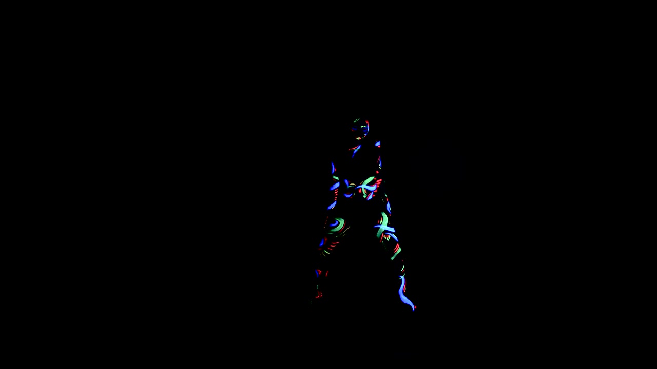 Female dancer in ultraviolet bodypaint moving her body close to the ground
