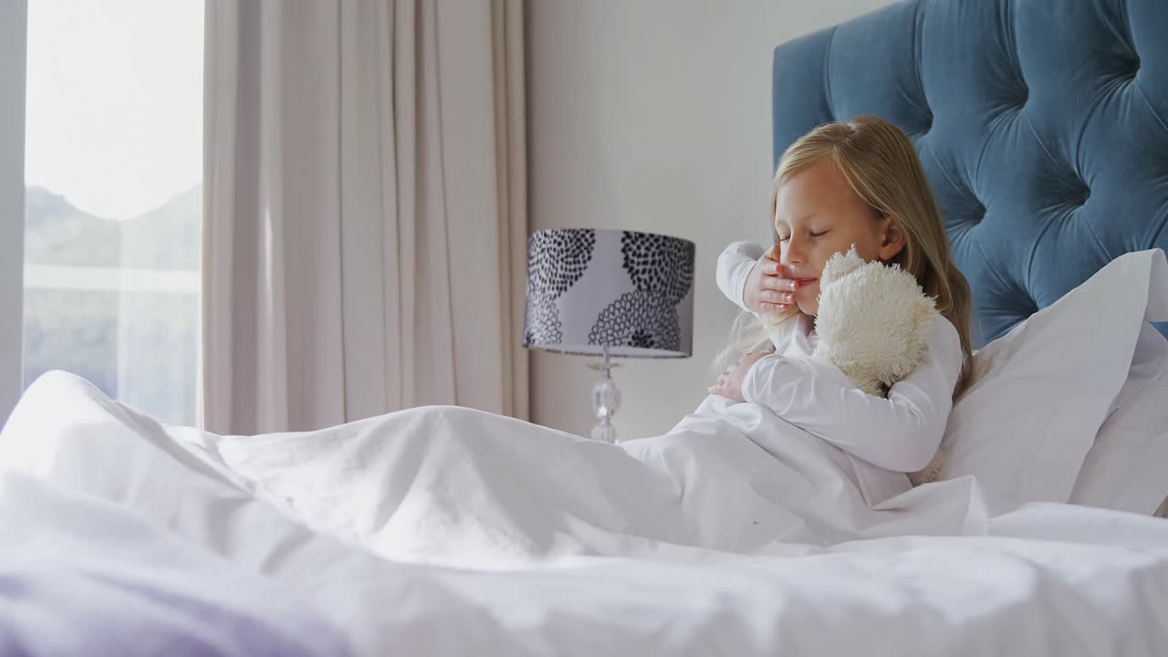 chica estirando los brazos mientras se despierta en el dormitorio 4k