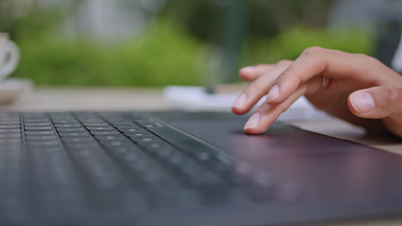 Lady fingers touching laptop touchpad at outdoors cafeteria closeup. Woman hands
