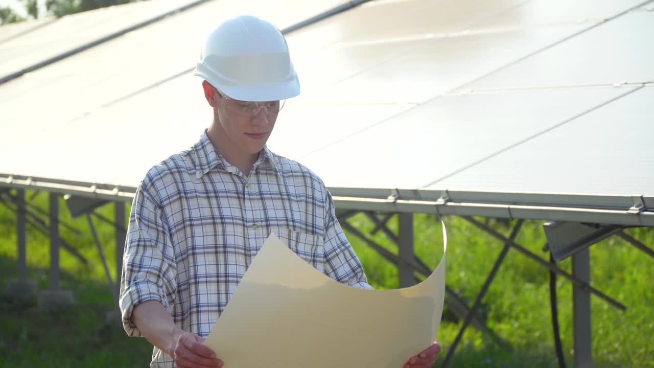Engenheiro com capacete branco está na usina solar. Painel fotovoltaico.