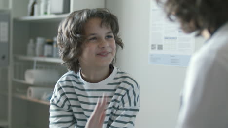 little boy giving high five to doctor during medical check-up at clinic