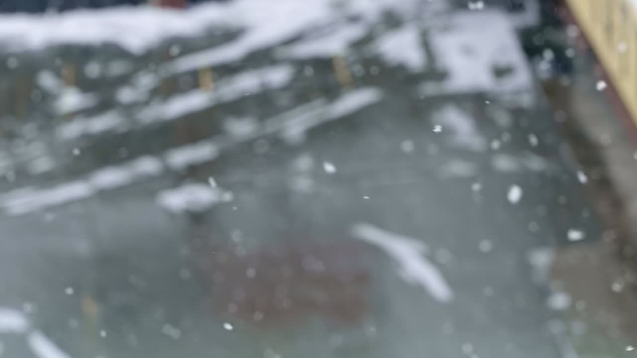 유타의 추운 겨울 눈보라 속에서 배경이 초점이 맞지 않은 채 눈이 휘날리며 땅으로 빠르게 떨어지는 슬로우 모션 삼각대 샷