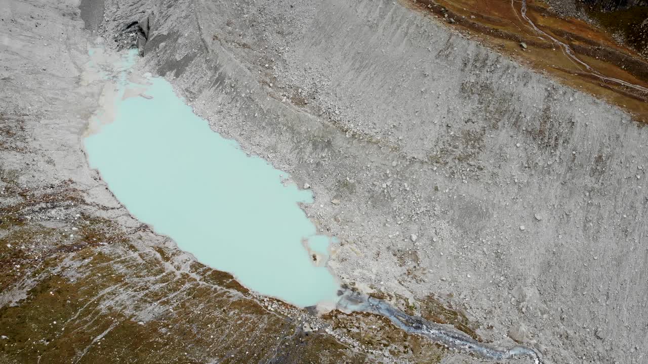 вид с воздуха на ледник муари возле грименца в вале, швейцария, с панорамой от небольшого ледникового озера до льда и горных вершин, скрывающихся в облаках