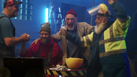 group of blue-collar workers cheering and reacting to an event