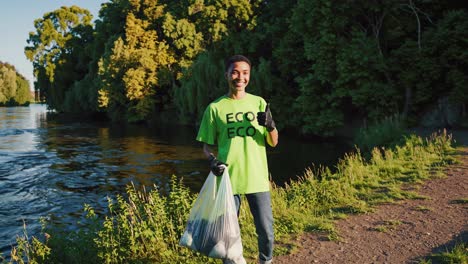 smiling volunteer cleaning up riverbank
