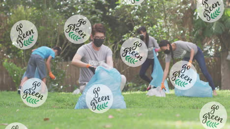 animation of leaves and go green text over diverse volunteers collecting plastics in bags at park