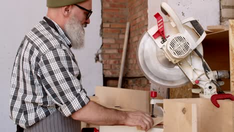carpenter working with electrical circular saw