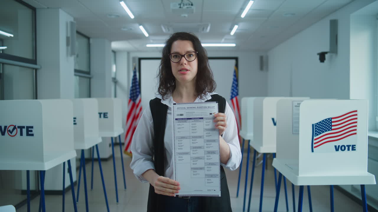 American Female Voter Speaks on Camera Shows Paper Ballot American Female Voter or Polling Officer Speaks on Camera Shows Paper Ballot Calls for Voting National Election Day in the United States Voting Booths at Polling Station Civic Duty and Patriotism