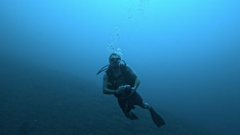 imágenes de un buzo con una cámara submarina, explorando el océano azul profundo y capturando la vida marina