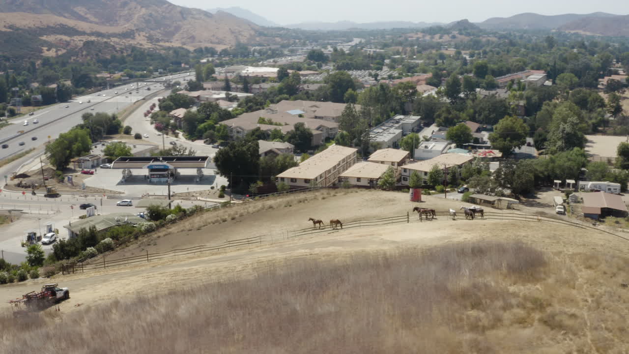 Vista aerea di cavalli da sentiero ad Agoura, California, con l'autostrada 101 sullo sfondo.