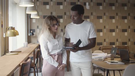 manager showing tablet screen to colleague