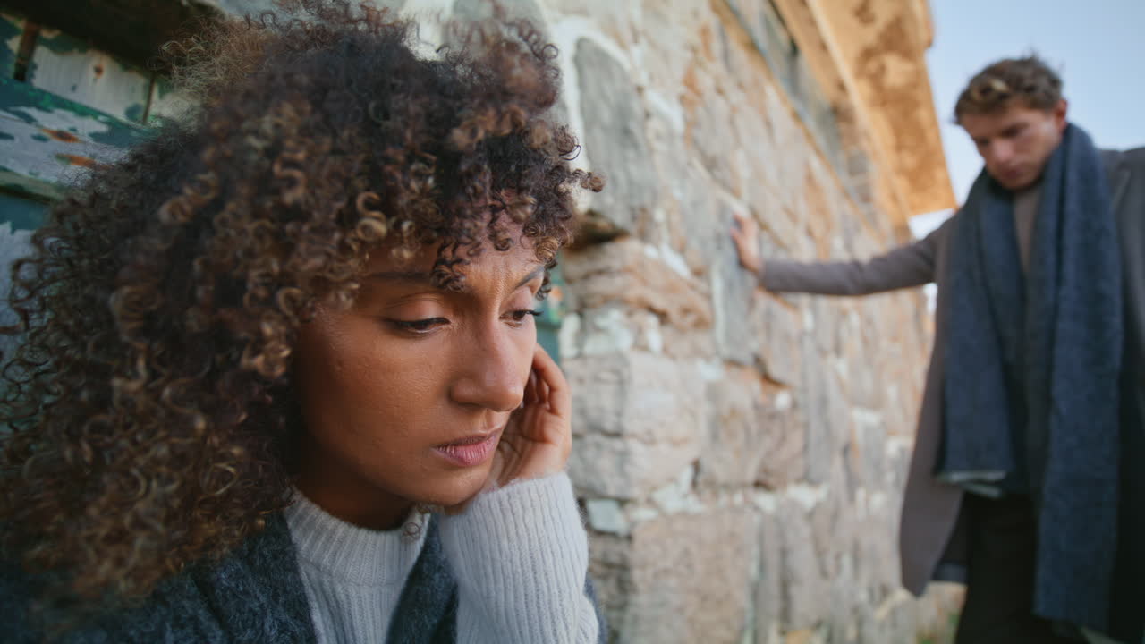 Frustrated woman ignoring boyfriend at stoned castle closeup. Pair in crisis