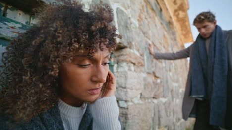 frustrated woman ignoring boyfriend at stoned castle closeup. pair in crisis