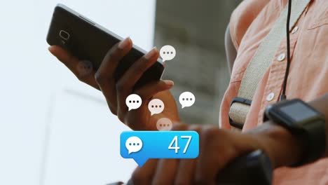 animation of message icon over mid section of african american woman using smartphone