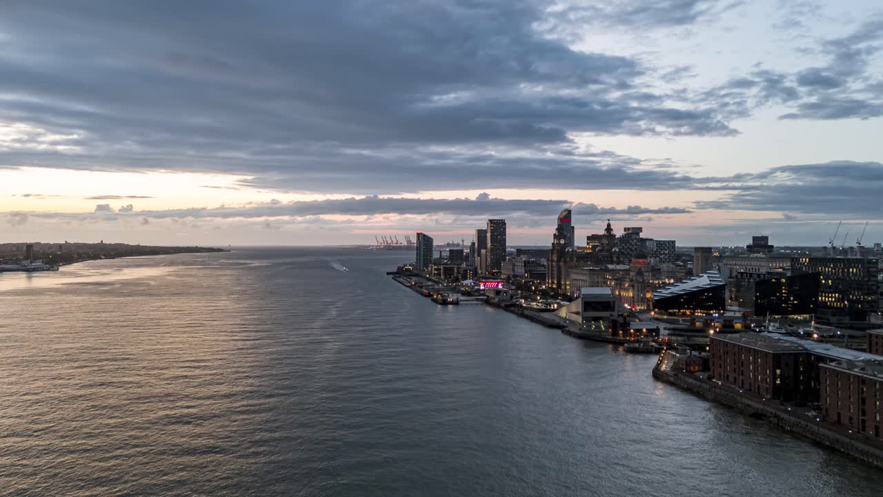 Fiume Mersey, lungofiume di Liverpool al tramonto, skyline della città, Pier Head e nuvole in movimento, Inghilterra, Regno Unito. Drone aereo, Time-lapse motion-lapse