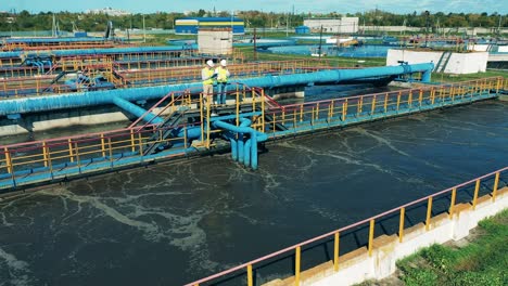 vista aérea de dos trabajadores observando un sistema de tratamiento de aguas residuales