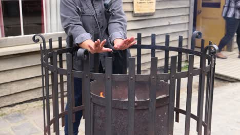 person warming hands by fire in ballarat market