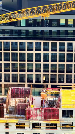 Urban construction site with crane. Workers engage in construction at a building site overlooking a modern urban landscape with a crane operating overhead
