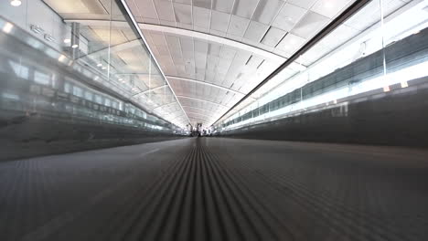 vista a nivel del suelo de una cinta de correr del corredor de la pasarela móvil del aeropuerto, concepto de fondo del aeropuerto