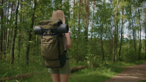 slow motion: traveling happy woman with backpack walking on path the tropical forest