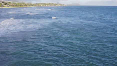 drone footage of the pacific as the waves crash to the sandy shores of oahu in the hawaiin islands near honolulu