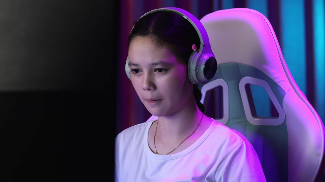 컴퓨터에서 비디오 게임을 하는 심각한 아시아 십대 소녀 게이머의 근접