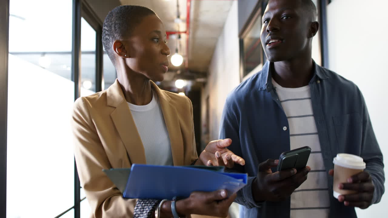 Diverse business people talking and walking in office, slow motion, copy space