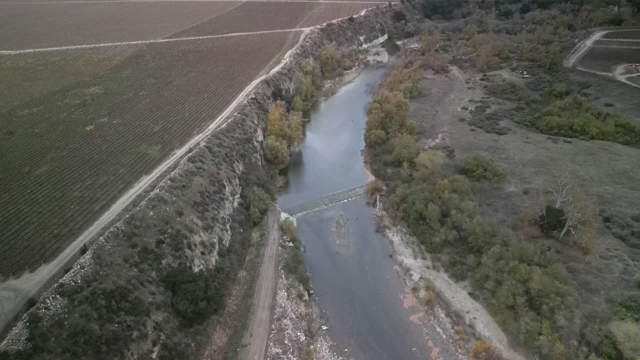 vista aérea capturando el río arroyo seco serpenteando a través de viñedos y tierras de cultivo en greenfield, california, ee.uu., ilustrando la mezcla de naturaleza y agricultura.