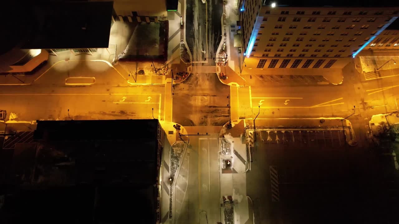 Cinematic top-down aerial of a glowing city intersection in downtown Youngstown, Ohio, with amber lighting and clean grid layout.