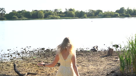 mujer salta con alegría a un lago