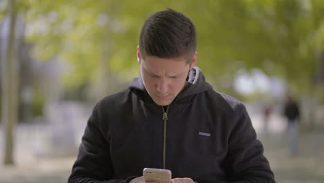 focused young man using smartphone outdoor