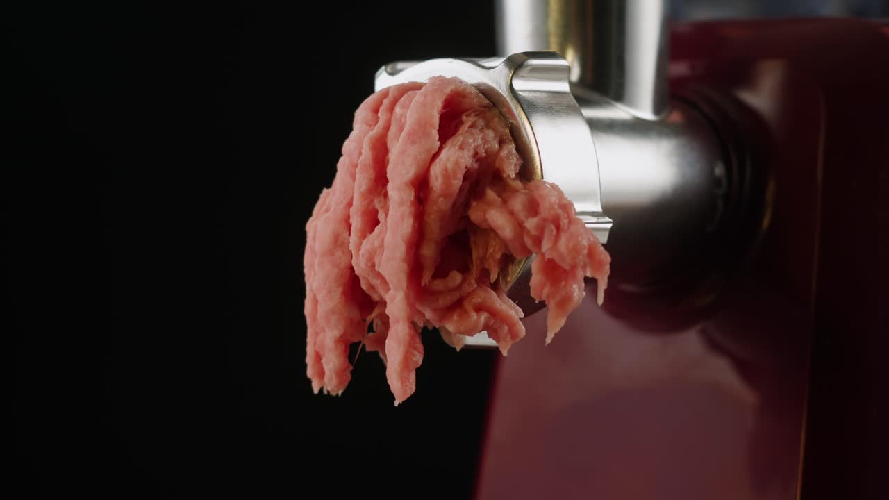 Viande hachée sortant d'un hachoir à viande.