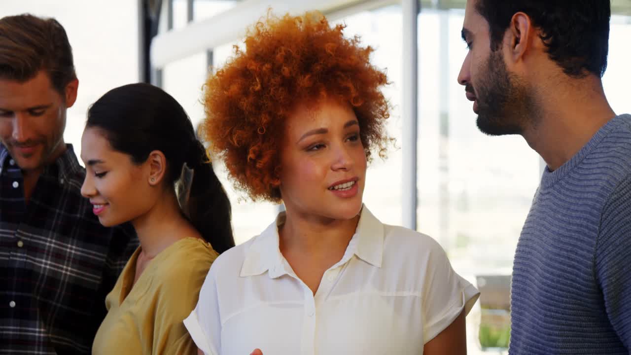 ejecutivos interactuando mientras usan tabletas digitales