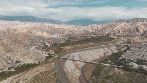 receding aerial movement from the rio calchaqui bridge at the quebrada de las flechas, salta, argentina, south america