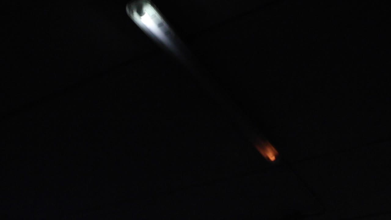 부서진 차고 네온 불빛이 깜박이는 어둡고 혼란스러운 장면