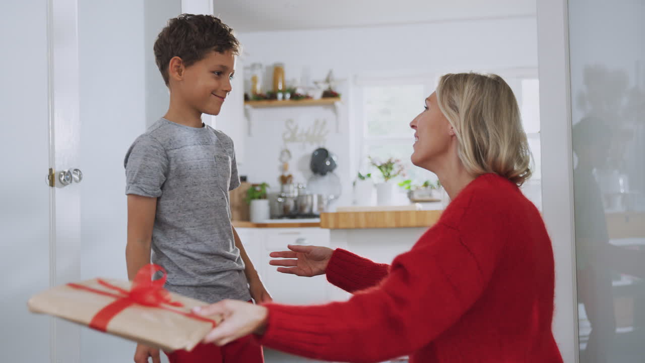 아들 은 집 에서 크리스마스 아침 에 어머니 에게 선물 을 준다