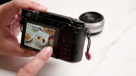 close-up of a person browsing all the saved images in a small point-and-shoot digital camera