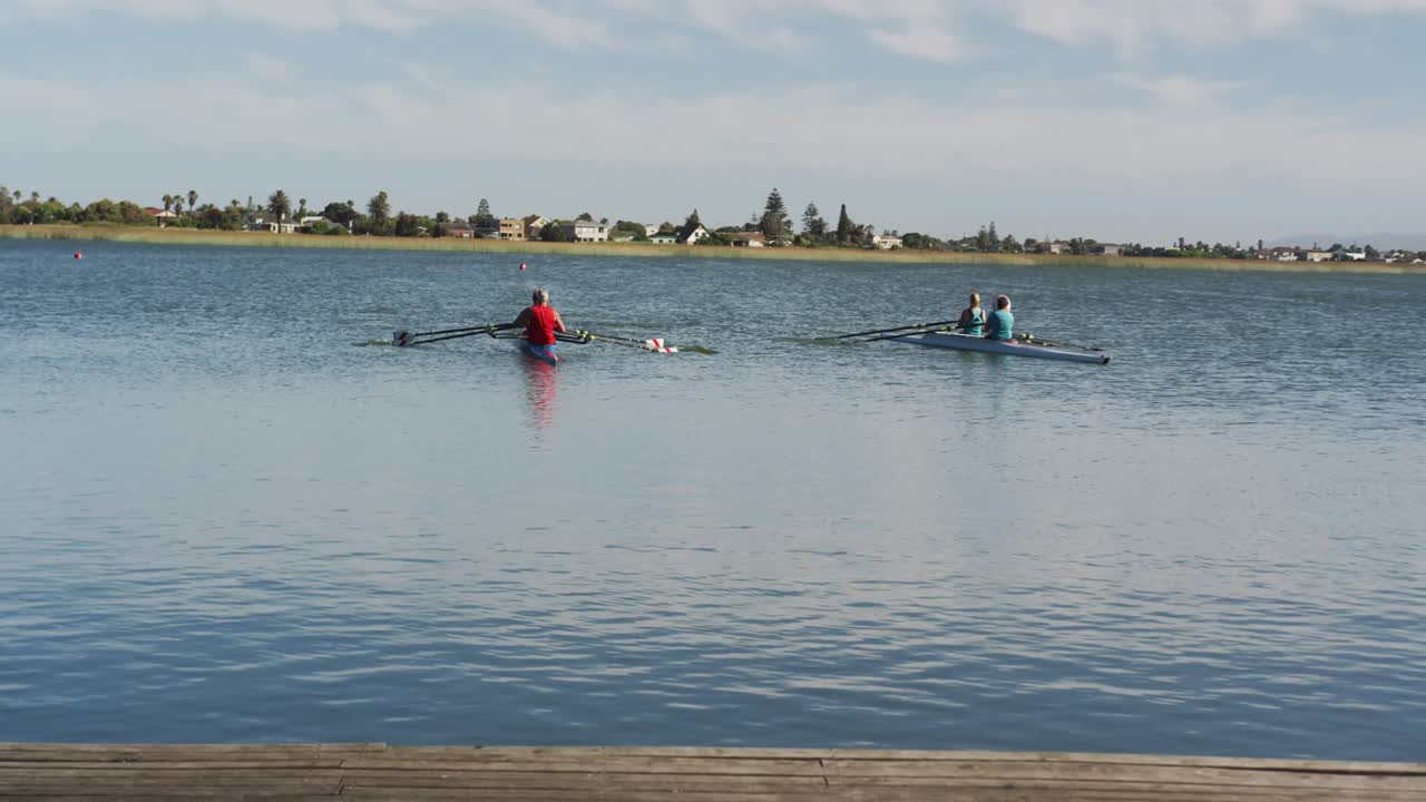 Four senior caucasian men and women rowing boat on a river