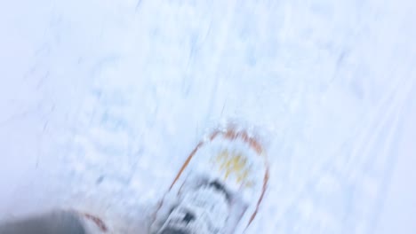 A-point-of-view-shot-of-old-school-traditional-snow-shoes-hiking-through-thick-snow