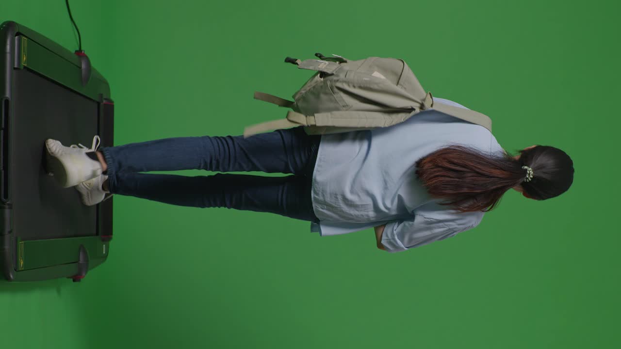 녹색 스크린 배경 스튜디오에서 트레드밀을 는 동안 배을 가진 아시아 십대 소녀 학생의 몸이 가득 차 있습니다.